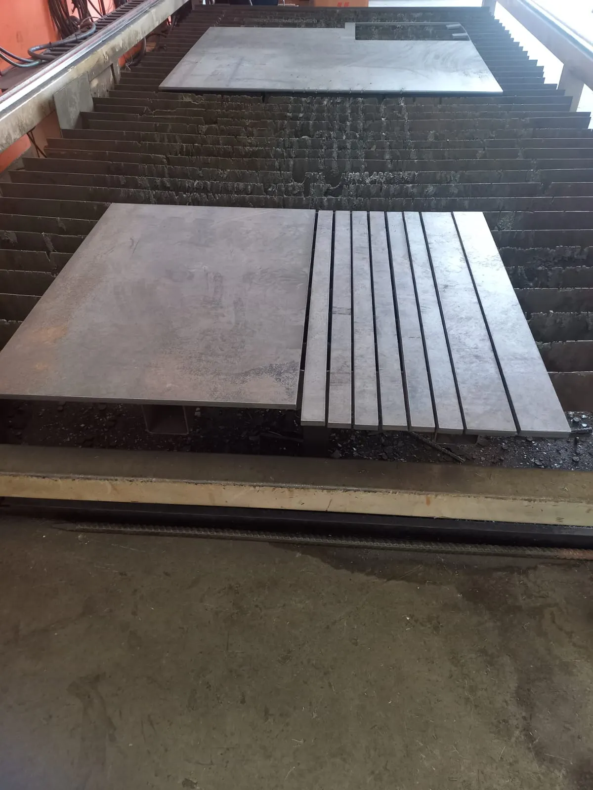 Barras de aço seriadas com largura constante sobre a mesa de corte